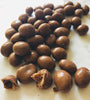 A short strip of chocolate coated sutltanas fill the image down the middle top to bottom. One is broken to demonstrate there are sultanas inside.