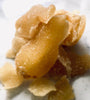 A few chunks of sweetened ginger are in the centre of the image. It is on a white marble background.