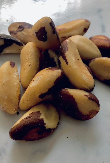 Fresh ready to eat Brazil nuts in a pile on a white marble table. 
