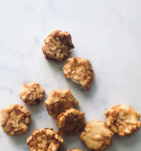 Small barbecue rice crackers on a white marble table.