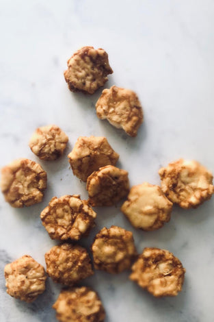 Small barbecue rice crackers on a white marble table.