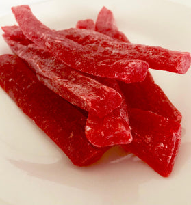 Dark red strips of paw paw piled in the middle of a white plate.