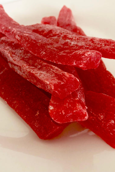 Dark red strips of paw paw piled in the middle of a white plate.